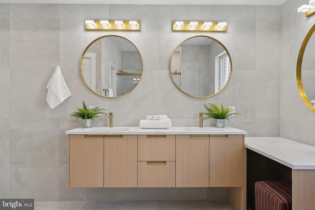 full bathroom featuring a sink, tile walls, and double vanity