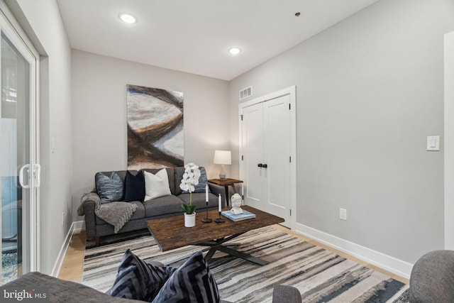 living room featuring recessed lighting, visible vents, light wood-type flooring, and baseboards