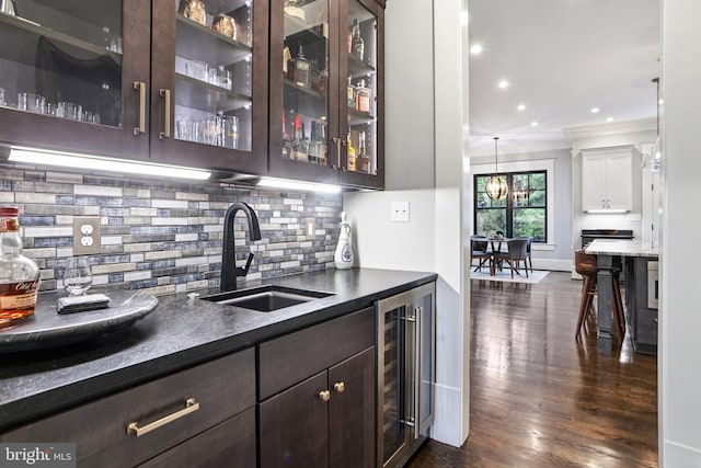 4777 33rd St N, Arlington, VA 22207 - bar featuring wet bar, a sink, dark wood-type flooring, crown molding, and decorative backsplash