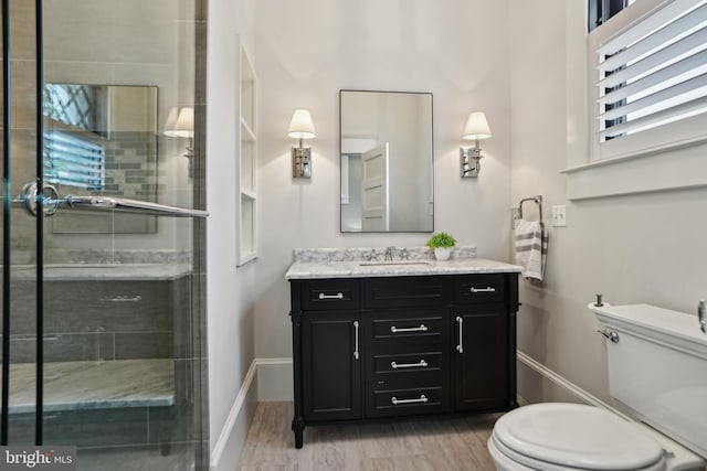 4777 33rd St N, Arlington, VA 22207 - bathroom with toilet, wood finished floors, a stall shower, vanity, and baseboards