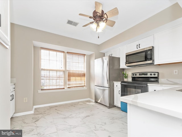 kitchen with appliances with stainless steel finishes, marble finish floor, baseboards, and visible vents
