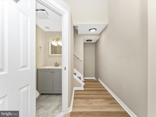 interior space with visible vents, baseboards, a sink, stairs, and marble finish floor