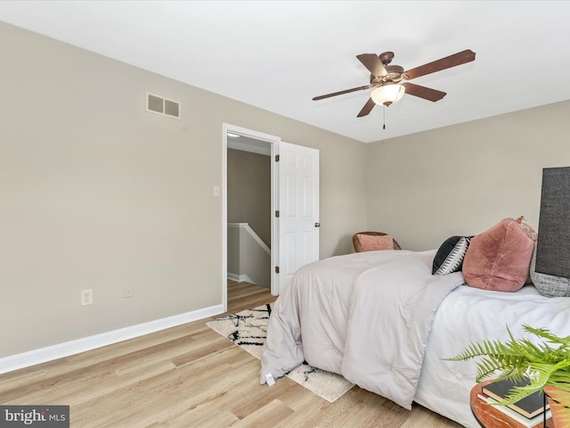 bedroom with light wood-style flooring, baseboards, a ceiling fan, and visible vents