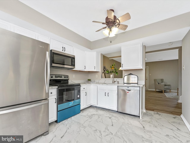 kitchen featuring marble finish floor, light countertops, white cabinetry, and stainless steel appliances