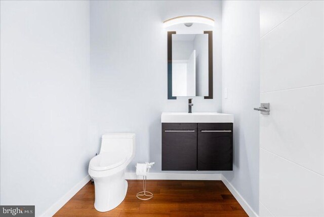 bathroom featuring toilet, baseboards, and wood finished floors