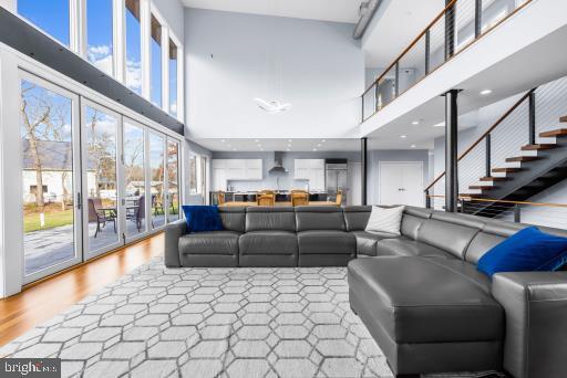 living area featuring recessed lighting, wood finished floors, and a towering ceiling