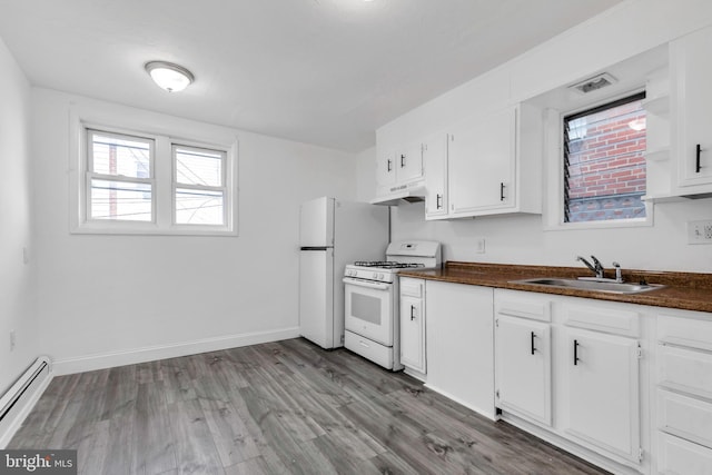 kitchen featuring a sink, dark countertops, under cabinet range hood, white range with gas stovetop, and a baseboard heating unit