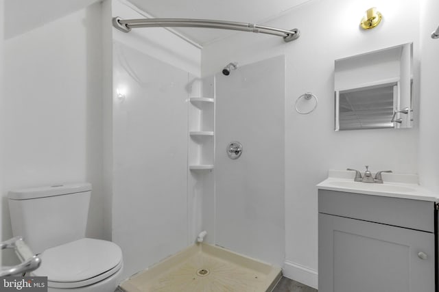 bathroom with toilet, a shower stall, and vanity