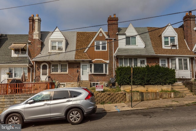 view of front of property with a chimney, a shingled roof, a residential view, and brick siding