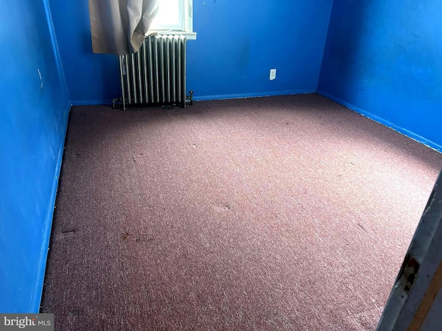 carpeted empty room with radiator