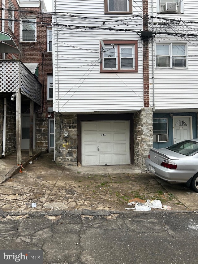 view of side of property featuring an attached garage and stone siding