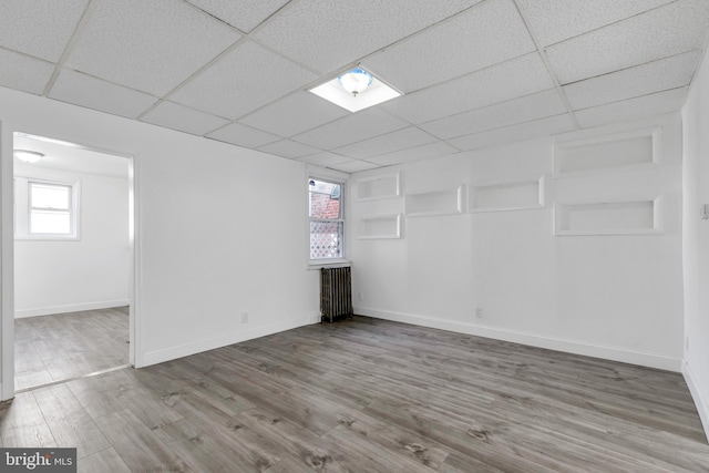 basement with a healthy amount of sunlight, baseboards, and wood finished floors