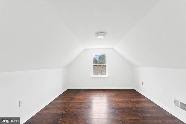 bonus room with baseboards, visible vents, hardwood / wood-style flooring, and vaulted ceiling