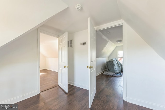 bonus room with vaulted ceiling, visible vents, baseboards, and wood finished floors