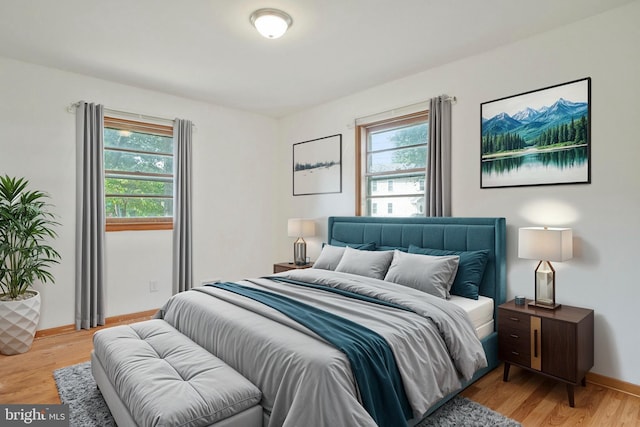 bedroom with light wood finished floors and baseboards
