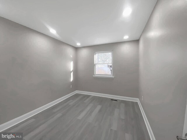spare room featuring visible vents, baseboards, recessed lighting, and wood finished floors