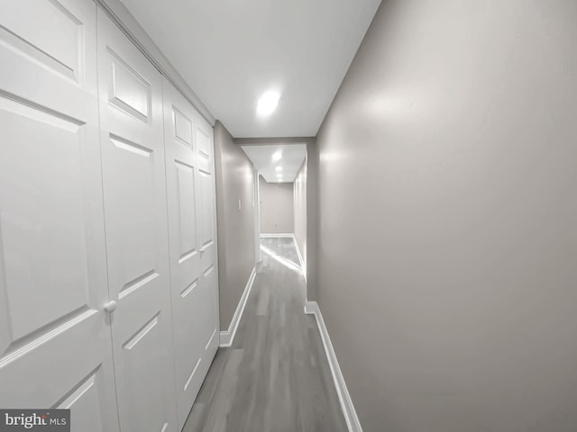 hall with baseboards and wood finished floors