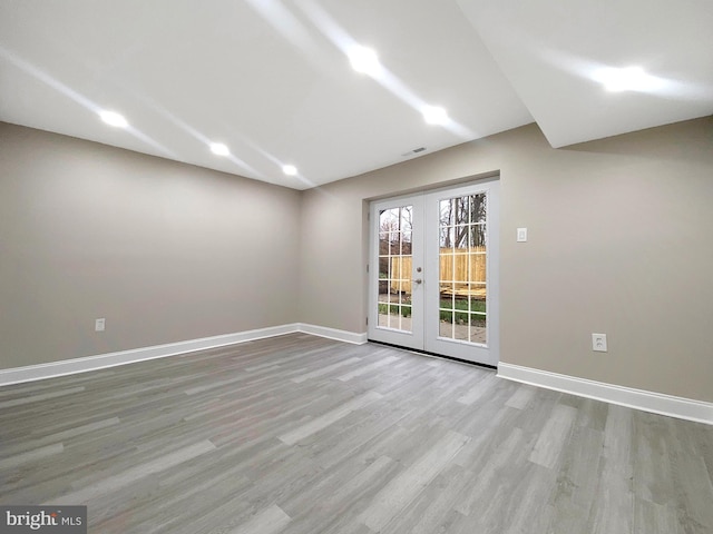 empty room with visible vents, french doors, baseboards, and wood finished floors
