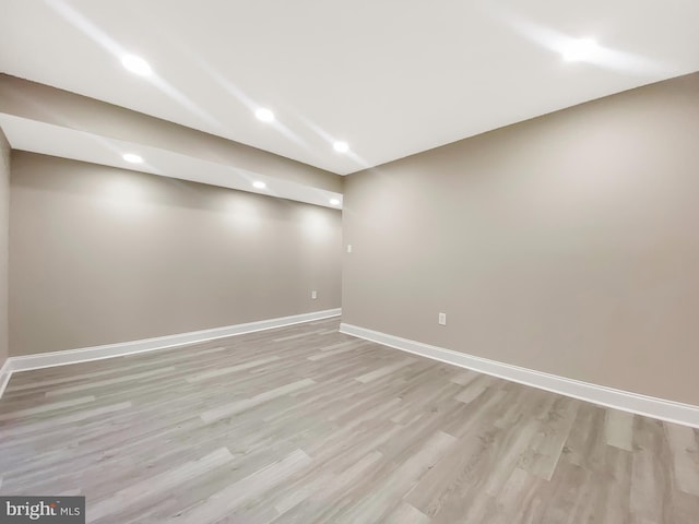 finished below grade area with baseboards, recessed lighting, and light wood-style floors