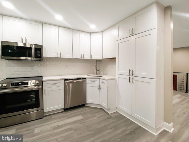 kitchen featuring appliances with stainless steel finishes, a sink, and white cabinets