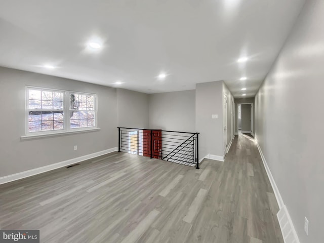 spare room with recessed lighting, visible vents, baseboards, and wood finished floors