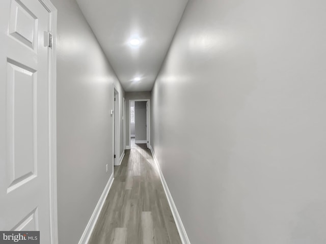 hall featuring baseboards and light wood finished floors
