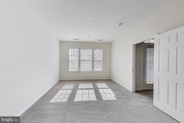 carpeted empty room with baseboards and visible vents