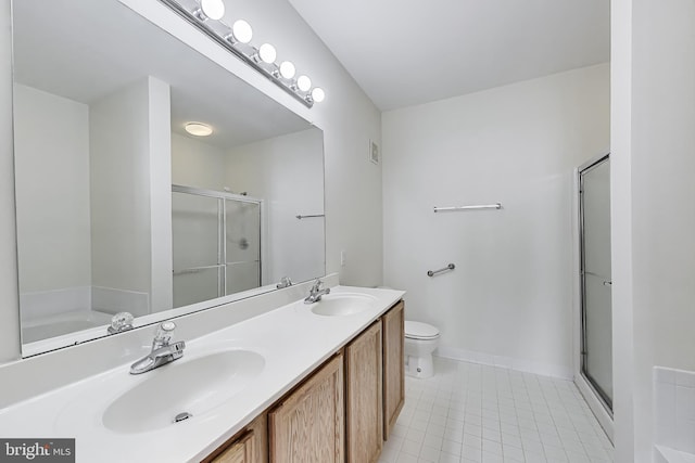bathroom with a sink, a shower stall, toilet, and double vanity