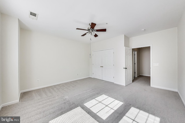 unfurnished bedroom with visible vents, a closet, baseboards, ceiling fan, and carpet