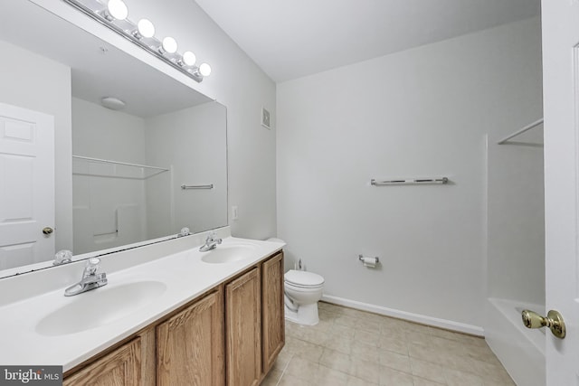 bathroom with double vanity, toilet, tile patterned floors, and a sink