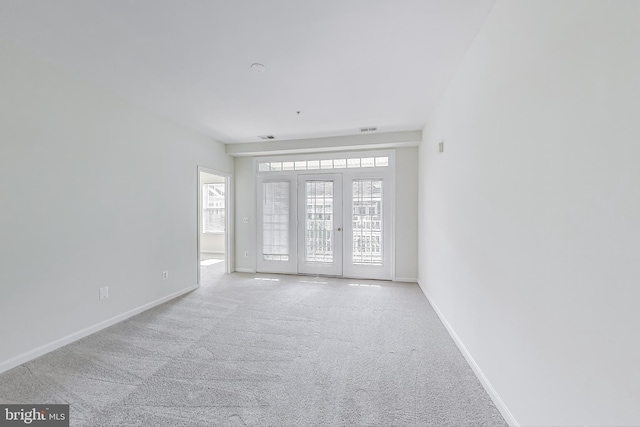 spare room with carpet, baseboards, and visible vents