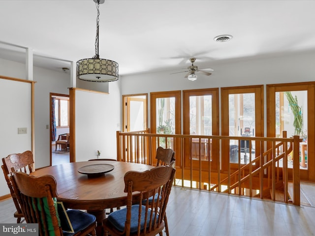 dining space featuring visible vents, a ceiling fan, and light wood finished floors