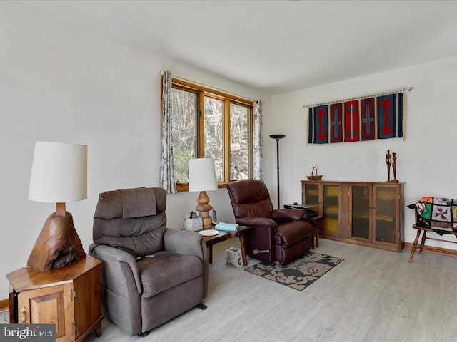 sitting room featuring baseboards and light wood-style floors