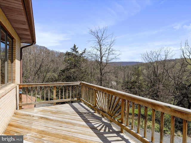 wooden terrace featuring a wooded view