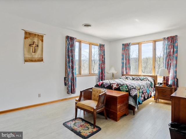 bedroom featuring light wood-style flooring, baseboards, and visible vents