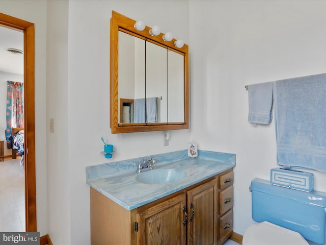 bathroom with toilet, vanity, and visible vents