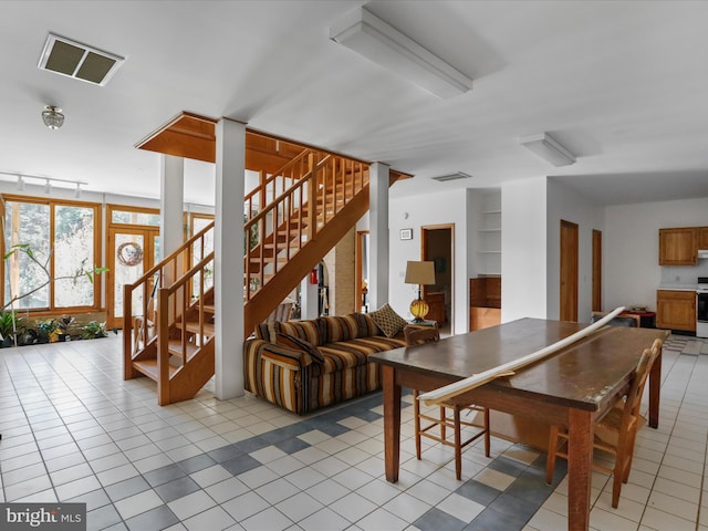 dining area with light tile patterned flooring, visible vents, and stairway