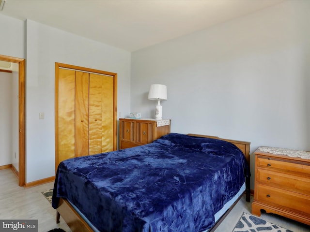 bedroom featuring a closet, baseboards, and light wood finished floors