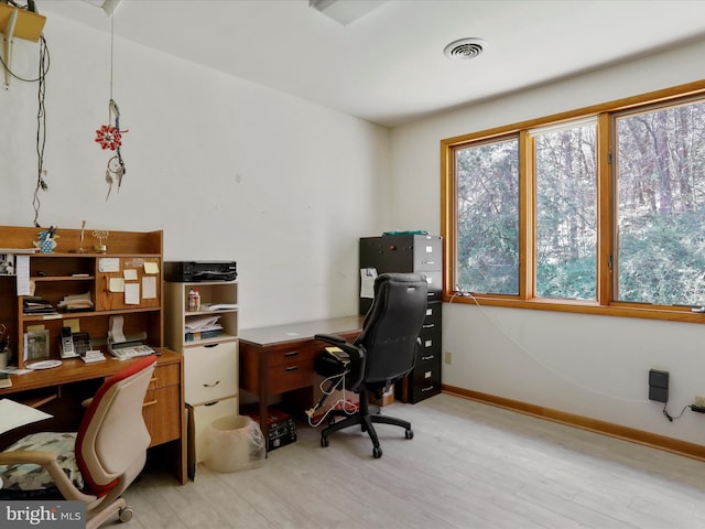 home office with visible vents, baseboards, plenty of natural light, and light wood-style floors