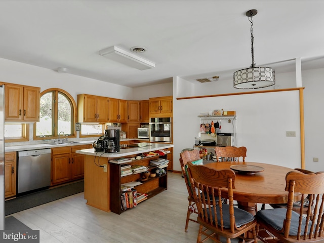 kitchen featuring a center island, light countertops, visible vents, appliances with stainless steel finishes, and a sink