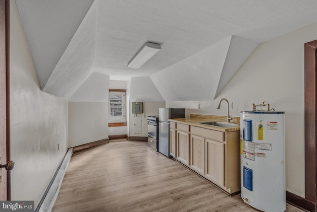 additional living space featuring water heater, vaulted ceiling, a sink, light wood-style floors, and a textured ceiling