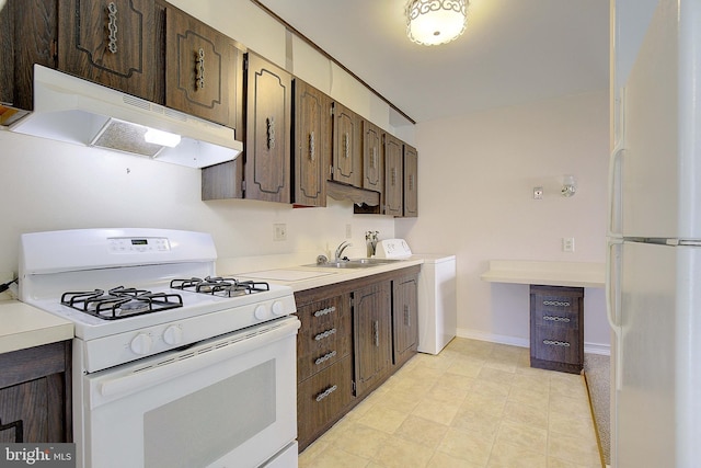 7203 Roanne Dr, Oxon Hill, MD 20745 - kitchen featuring washer / clothes dryer, a sink, white appliances, dark brown cabinetry, and under cabinet range hood