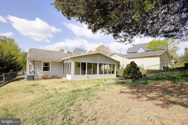7203 Roanne Dr, Oxon Hill, MD 20745 - rear view of property with central AC, a sunroom, a lawn, fence, and a chimney