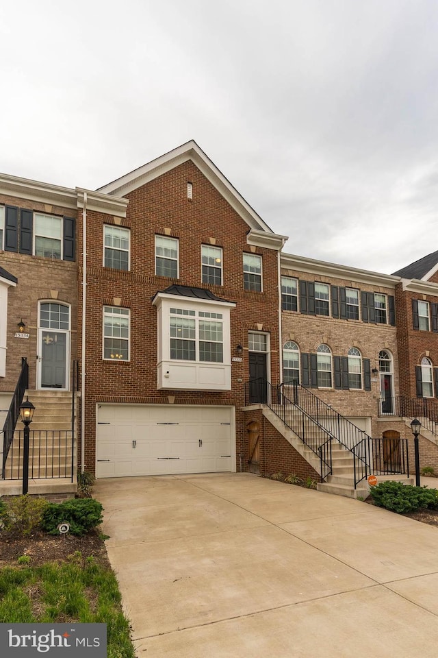 15332 Ballerina Loop, Woodbridge, VA 22193 - view of property featuring a garage, concrete driveway, and brick siding