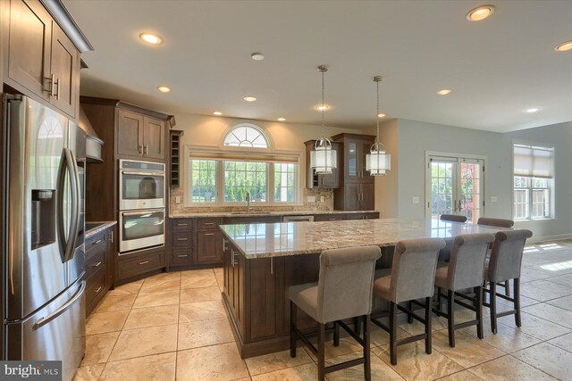 121 Rich Valley Rd, Mechanicsburg, PA 17050 - kitchen with light stone countertops, glass insert cabinets, a center island, a sink, and appliances with stainless steel finishes