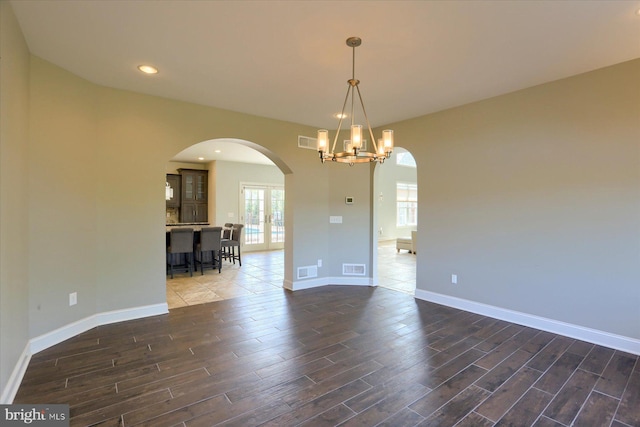 121 Rich Valley Rd, Mechanicsburg, PA 17050 - unfurnished room with visible vents, arched walkways, baseboards, dark wood-style floors, and a notable chandelier