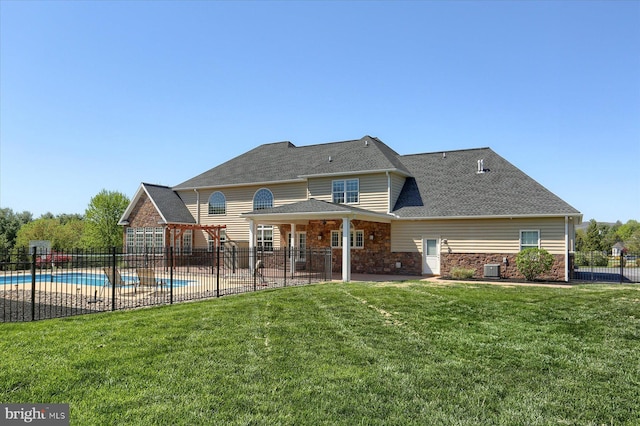 121 Rich Valley Rd, Mechanicsburg, PA 17050 - rear view of house featuring fence, stone siding, a fenced in pool, a patio area, and a yard