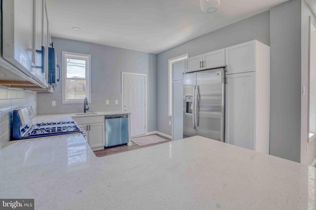 kitchen featuring a sink, light stone countertops, and stainless steel appliances