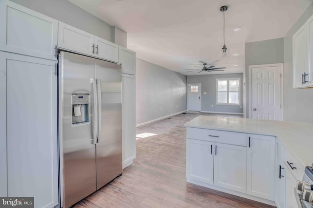 kitchen with stainless steel fridge with ice dispenser, a ceiling fan, white cabinetry, decorative light fixtures, and light wood finished floors