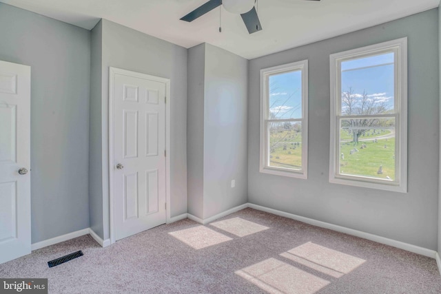 unfurnished bedroom with visible vents, baseboards, a ceiling fan, and carpet flooring